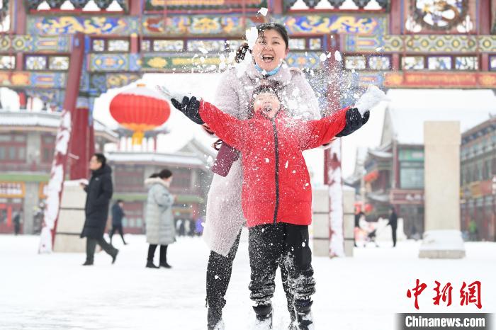 2月13日，家長與小朋友在呼和浩特市大召廣場享雪趣?！⑽娜A 攝