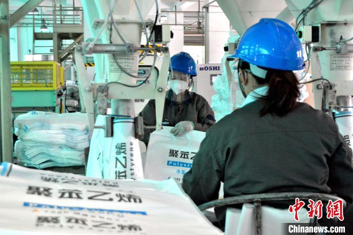 工人在生產(chǎn)線上包裝聚苯乙烯產(chǎn)品?！×趾霔v 攝