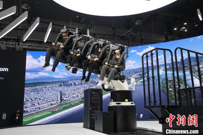 圖為觀眾在展會(huì)模擬體驗(yàn)未來(lái)城市空中移動(dòng)出行方式?！⑿?攝