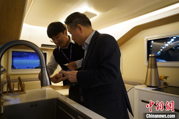 圖為參展商向觀眾介紹房車內(nèi)部設(shè)計(jì)?！⑿?攝