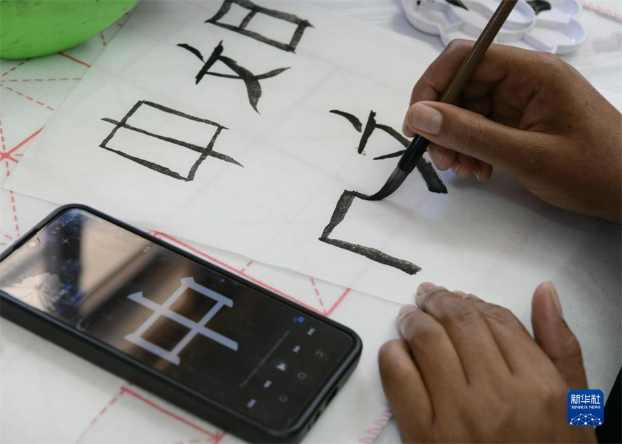 4月18日，肯尼亞學生在內(nèi)羅畢大學孔子學院舉辦的活動上寫毛筆字?？夏醽唭?nèi)羅畢大學孔子學院18日舉辦“中文，增進文明對話”主題活動，慶祝即將到來的第14個聯(lián)合國中文日?？夏醽唽W生參與互動，進行書法、剪紙、唱中文歌等活動。新華社記者 韓旭 攝