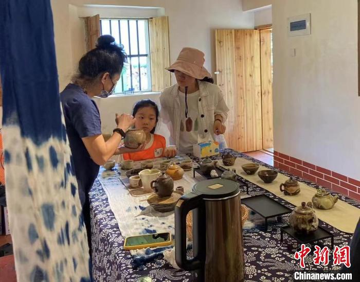 圖為：游客正在咨詢臺灣柴燒作品。　葉秋云 攝