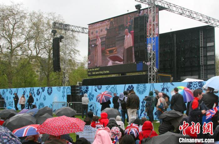 當(dāng)?shù)貢r間5月6日，英國國王查爾斯三世的加冕儀式舉行。民眾雨中觀看儀式。　歐陽開宇 攝