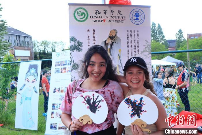 孩子們展示自己的吹墨畫團扇作品。　魯汶孔子學(xué)院供圖