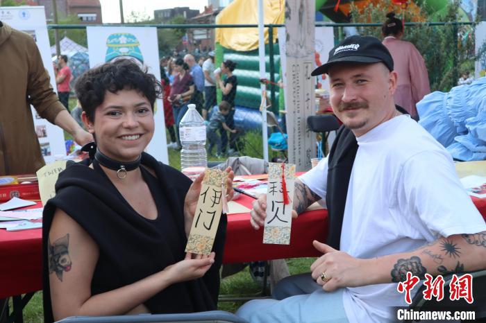 當(dāng)?shù)孛癖娫跐h字體驗工作坊展示自己手寫的中文名書簽?！◆斻肟鬃訉W(xué)院供圖