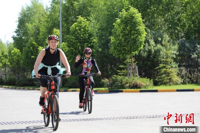 亞信副秘書長遲方(右一)與聯(lián)合國駐哈協(xié)調(diào)員在騎行活動中?！喰琶貢幑﹫D