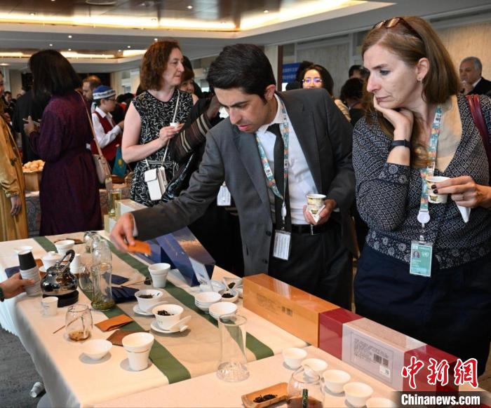 現(xiàn)場觀眾觀看中國展臺茶藝表演、了解茶文化。　靖樹 攝