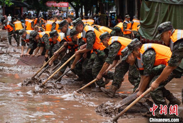 7月4日，萬(wàn)州區(qū)五橋街道，武警官兵清理街道上的淤泥?！∪矫宪?攝