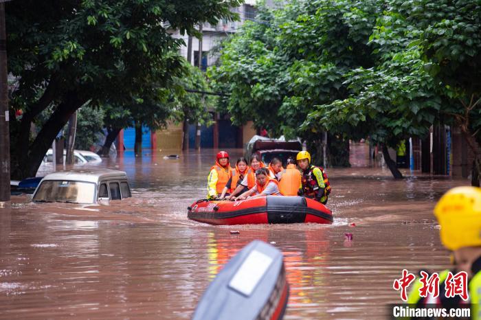 7月4日，萬(wàn)州區(qū)五橋街道，消防救援人員用沖鋒舟救援轉(zhuǎn)運(yùn)被困群眾。　冉孟軍 攝