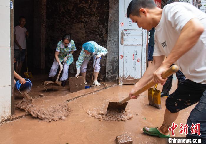7月4日，萬(wàn)州區(qū)五橋街道，洪水退去后，居民開(kāi)展清淤工作。　冉孟軍 攝