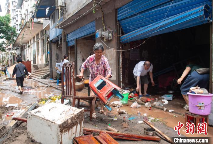 7月4日，萬(wàn)州區(qū)五橋街道，洪水退去后，居民搶救生活物資?！∪矫宪?攝