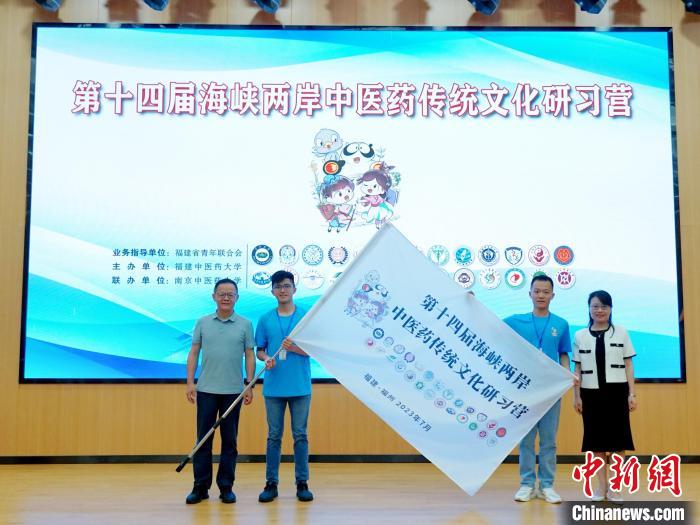 共青團(tuán)福建省委副書(shū)記吳雪(右一)、福建中醫(yī)藥大學(xué)黨委副書(shū)記林羽(左一)為兩岸學(xué)生代表頒授營(yíng)旗。　許燁婷 攝