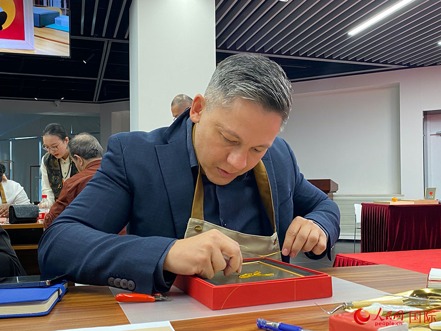 2023“一帶一路”媒體合作論壇聯(lián)合采訪團(tuán)團(tuán)員，親身體驗景泰藍(lán)工藝。人民網(wǎng)記者 于洋攝