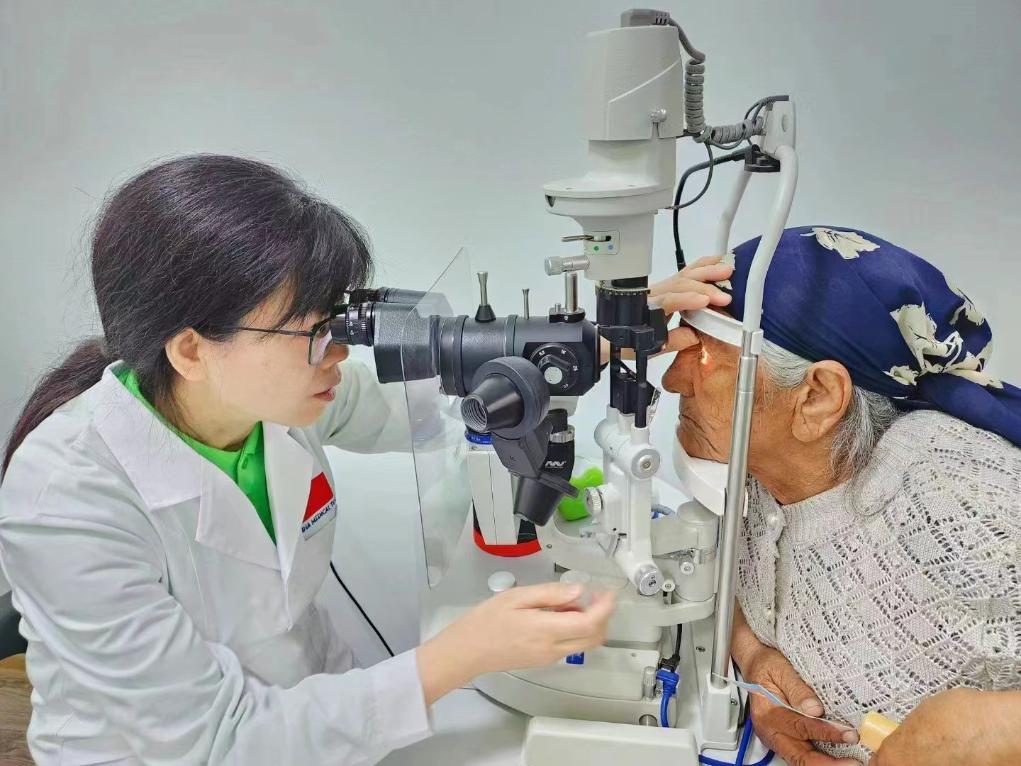 北京大學(xué)人民醫(yī)院眼科醫(yī)生鮑永珍正在為中亞白內(nèi)障患者進(jìn)行眼部檢查。（北京大學(xué)人民醫(yī)院供圖）