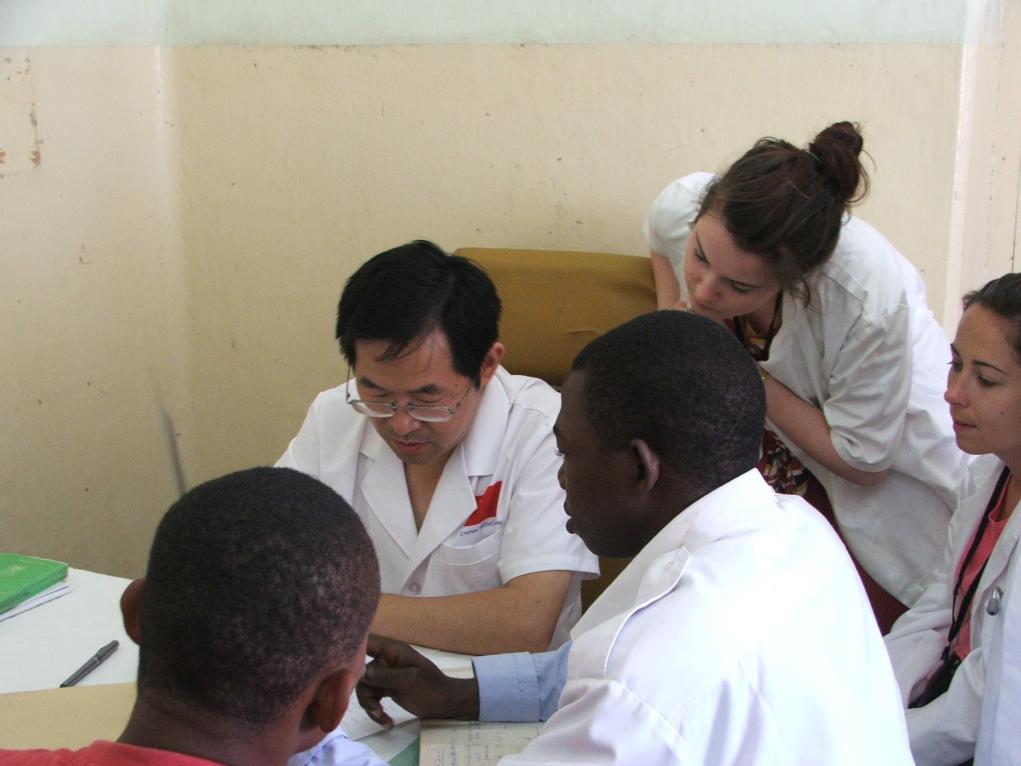 2011年7月22日，在坦桑尼亞桑給巴爾納茲莫加醫(yī)院外科門診，中國第24批援桑給巴爾醫(yī)療隊(duì)隊(duì)長盧建林為當(dāng)?shù)鼗颊咴\治并帶教實(shí)習(xí)生。新華社發(fā)（國家衛(wèi)生健康委供圖）