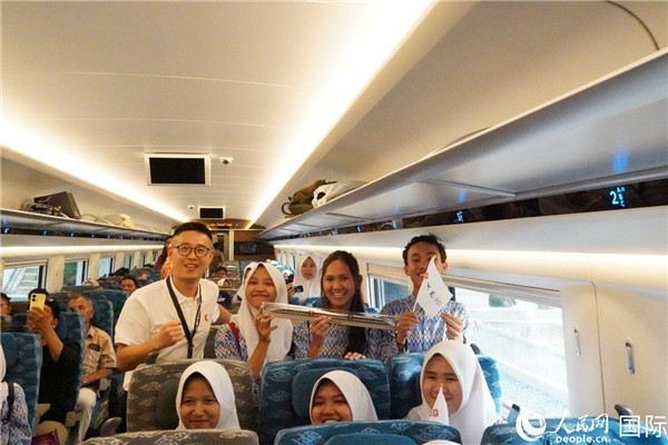 第一次乘坐雅萬高鐵動車組的學生們與動車組模型合影。人民網(wǎng)記者曹師韻攝