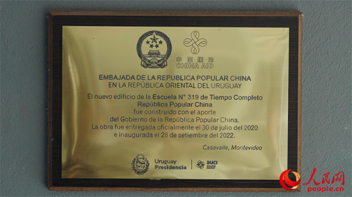 小學墻上懸掛的中國援助標識。人民網(wǎng)記者 張若涵攝