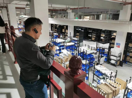 2023“一帶一路”媒體合作論壇聯(lián)合采訪團(tuán)團(tuán)員在仁和醫(yī)藥物流園拍攝記錄轉(zhuǎn)運(yùn)流程。（本報記者 黃超攝）