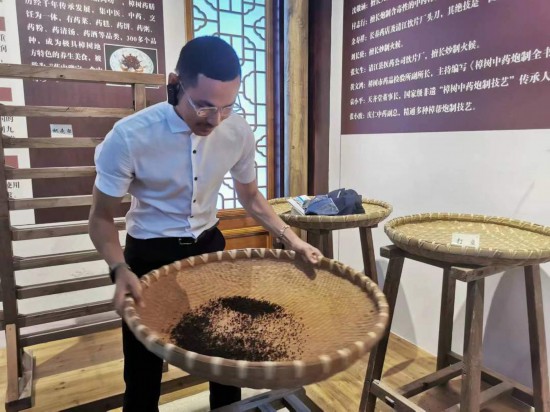 2023“一帶一路”媒體合作論壇聯(lián)合采訪團(tuán)團(tuán)員在非遺文化展示館體驗中藥炮制技藝。（本報記者 黃超攝）