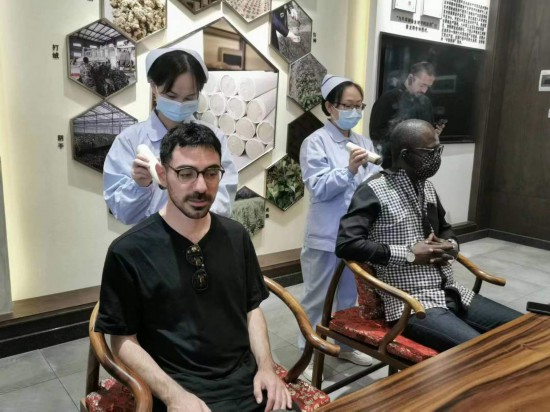 2023“一帶一路”媒體合作論壇聯(lián)合采訪團(tuán)團(tuán)員在九牛草展示館體驗艾灸。（本報記者 黃超攝）