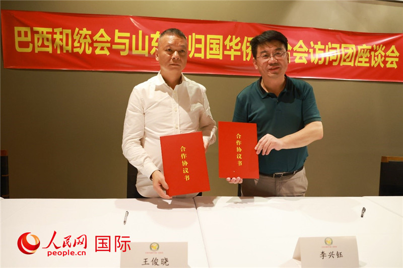 中國僑聯(lián)副主席、山東省僑聯(lián)主席李興鈺（右）與巴西和統(tǒng)會會長王俊曉簽署合作協(xié)議書。人民網(wǎng)記者 陳海琪攝