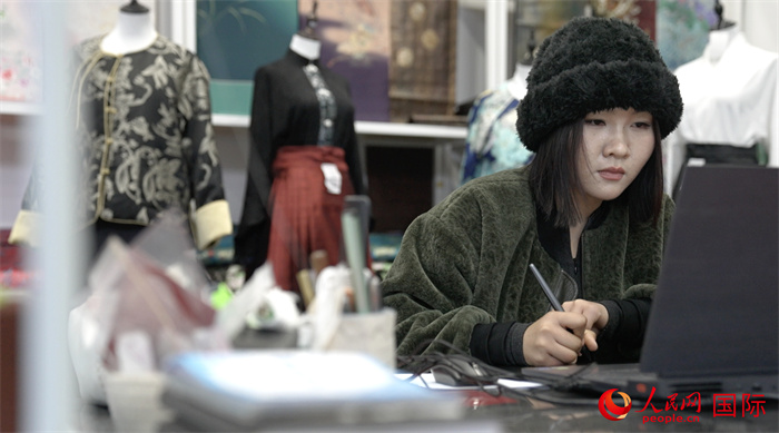 1月23日，在山東省菏澤市曹縣有愛云倉直播基地，張子晨正在設(shè)計漢服。 人民網(wǎng)記者 袁蒙攝