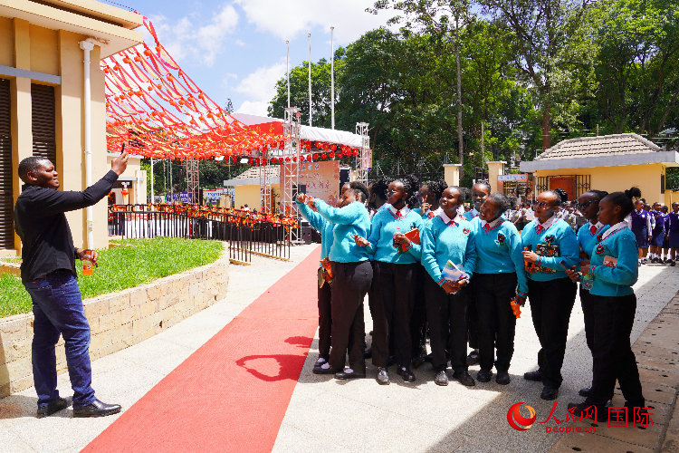 一名老師在給學生拍照留念。人民網(wǎng)記者 黃煒鑫攝