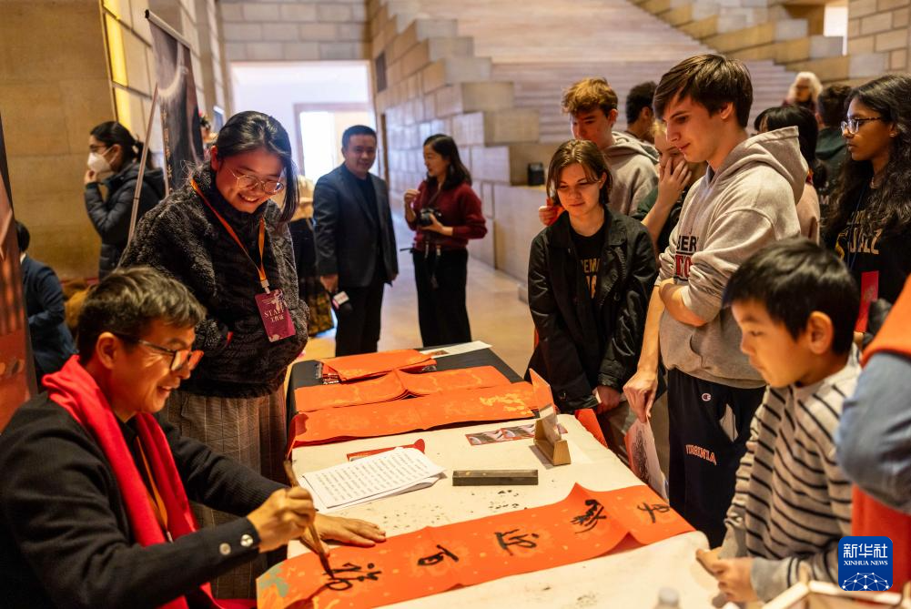 2月11日，書法家在美國費城藝術博物館舉行的龍年迎新春活動上為參觀者書寫對聯(lián)。新華社發(fā)（周煥新攝）