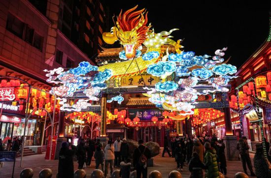 2月11日，游客在沈陽中街游覽。春節(jié)期間，各地?zé)艋痂病⒒饦溷y花，呈現(xiàn)出一幕幕流光溢彩的視覺盛宴。（新華社記者潘昱龍攝）