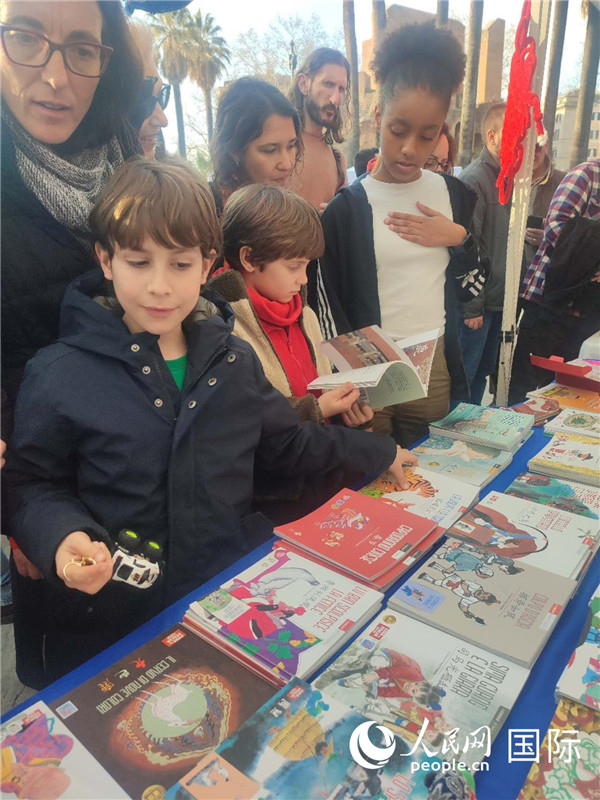 印刷精美的中國傳統(tǒng)文化叢書吸引了小游客的注意。人民網(wǎng)記者鄭彬攝