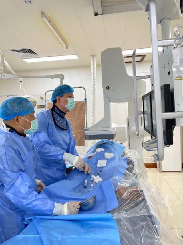 李凱教授（右）和劉海濤教授（左）為患者行TACE手術。中國駐老撾大使館供圖