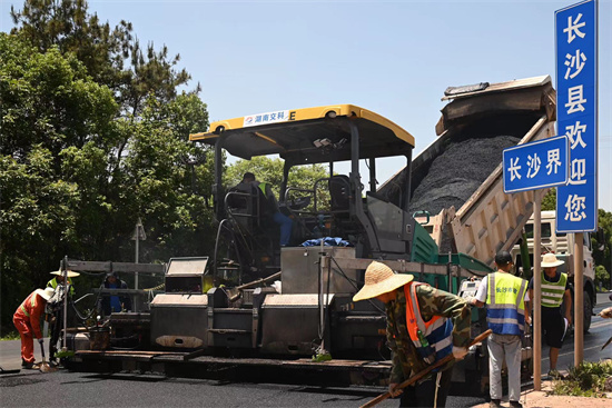 工人正在進(jìn)行“極薄磨耗層”路面的鋪筑。受訪單位供圖