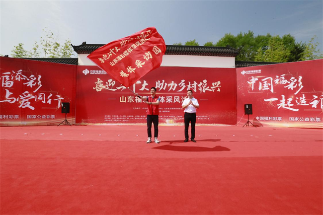 為媒體采風(fēng)團(tuán)授旗。 山東省福彩供圖