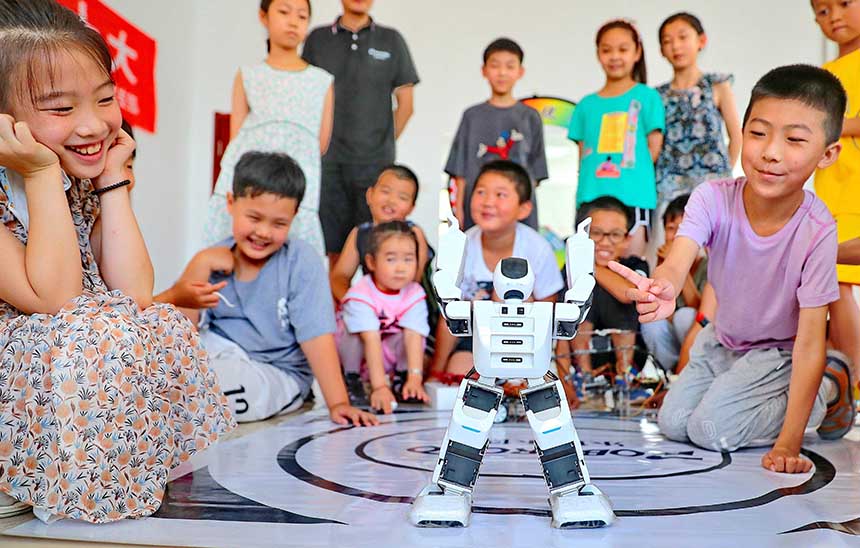 2022年7月19日，河北省秦皇島市海港區(qū)白塔嶺街道秦皇半島第二社區(qū)內(nèi)，小朋友正在觀看“機(jī)器人跳舞”。 曹建雄攝