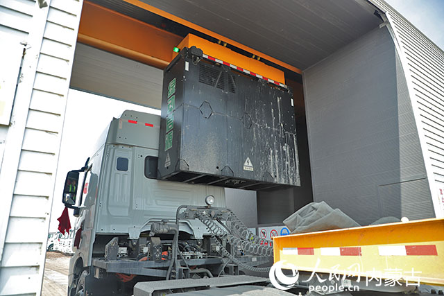 萬利新能源數(shù)字陸港里，正在充換電站進(jìn)行換電的重卡。人民網(wǎng)記者 趙夢月攝