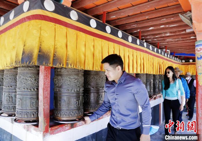 圖為外籍嘉賓體驗藏族傳統(tǒng)轉(zhuǎn)經(jīng)筒?！●R銘言 攝