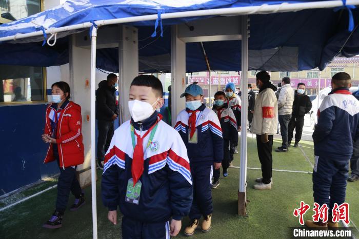 圖為學(xué)生測量體溫后進(jìn)入校園?！●R銘言 攝