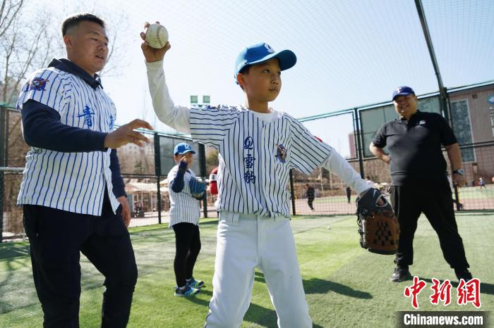 圖為教練指導(dǎo)小棒球手?jǐn)S球技術(shù)?！●R銘言 攝