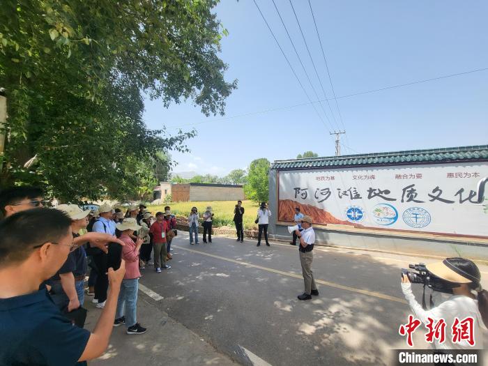 圖為中國地質(zhì)大學(xué)(北京)教授張緒教介紹村落情況?！『衍?攝