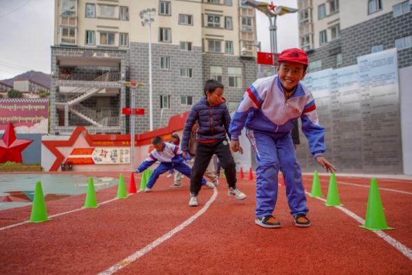 在高原上教孩子們打手球，“慢慢兒來，甭著急！”