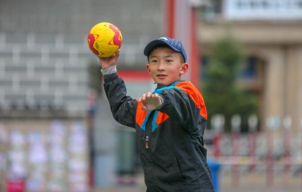 在高原上教孩子們打手球，“慢慢兒來，甭著急！”