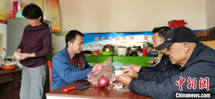 圖為扶貧路上“臨時(shí)一家人”準(zhǔn)備午餐?！∥航ㄜ?攝