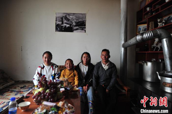 圖為8月12日，2018年7月從距那曲市色尼區(qū)城區(qū)那曲鎮(zhèn)90千米外的古露鎮(zhèn)當桑村搬遷至城區(qū)的旦增(右一)與家人在80多平方米的新家合影(資料圖)?！垈?攝