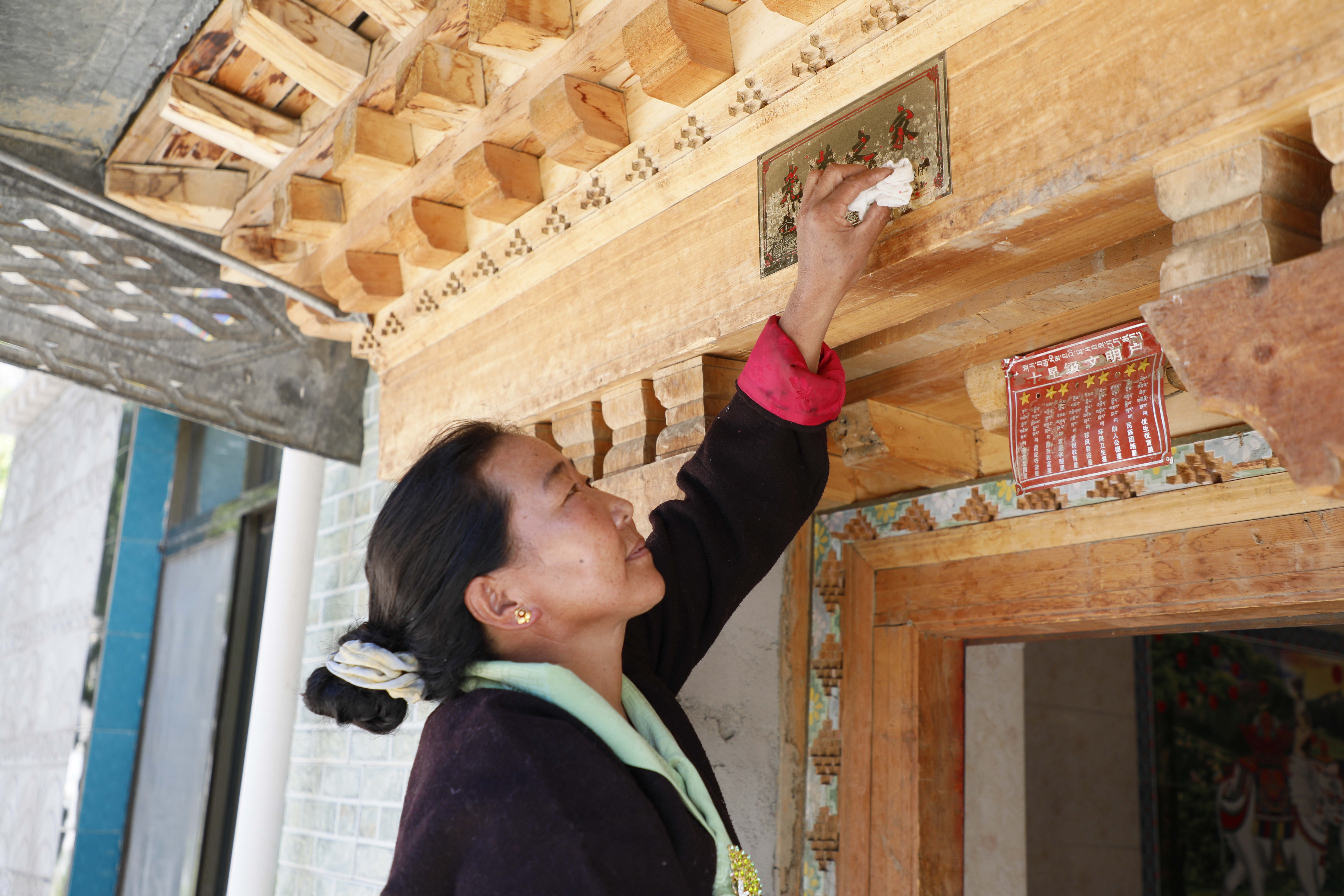 貢秋曲珍擦拭“光榮之家” 牌 應(yīng)俊攝.jpg?x-oss-process=style/w10 貢秋曲珍擦拭“光榮之家” 牌 應(yīng)俊攝.jpg?x-oss-process=style/w10