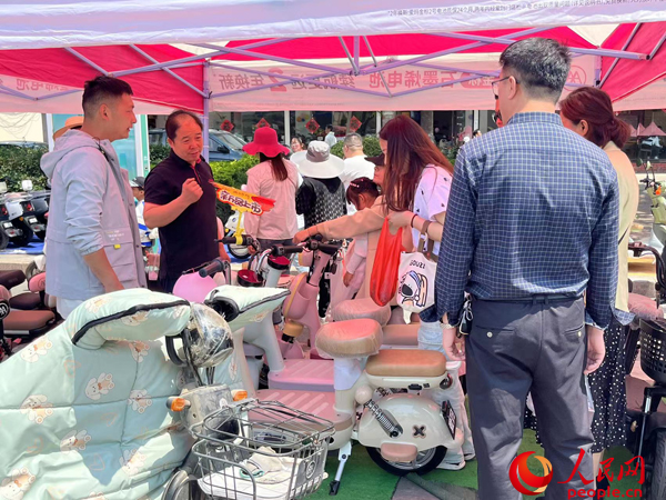 某電動自行車品牌工作人員向消費者介紹以舊換新相關(guān)情況。人民網(wǎng)記者 杜燕飛攝