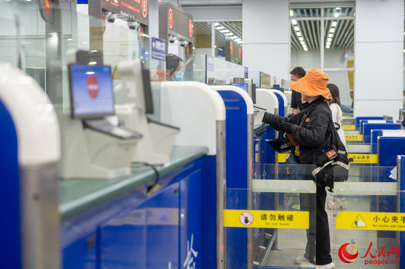 越南游客正在辦理入境手續(xù)。人民網(wǎng)記者 嚴(yán)立政攝