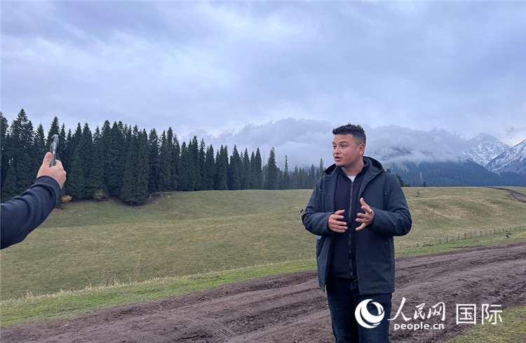 在庫爾德寧，吾買爾江被雪山美景震撼，即興錄制了短視頻作品。人民網(wǎng)記者曾書柔攝