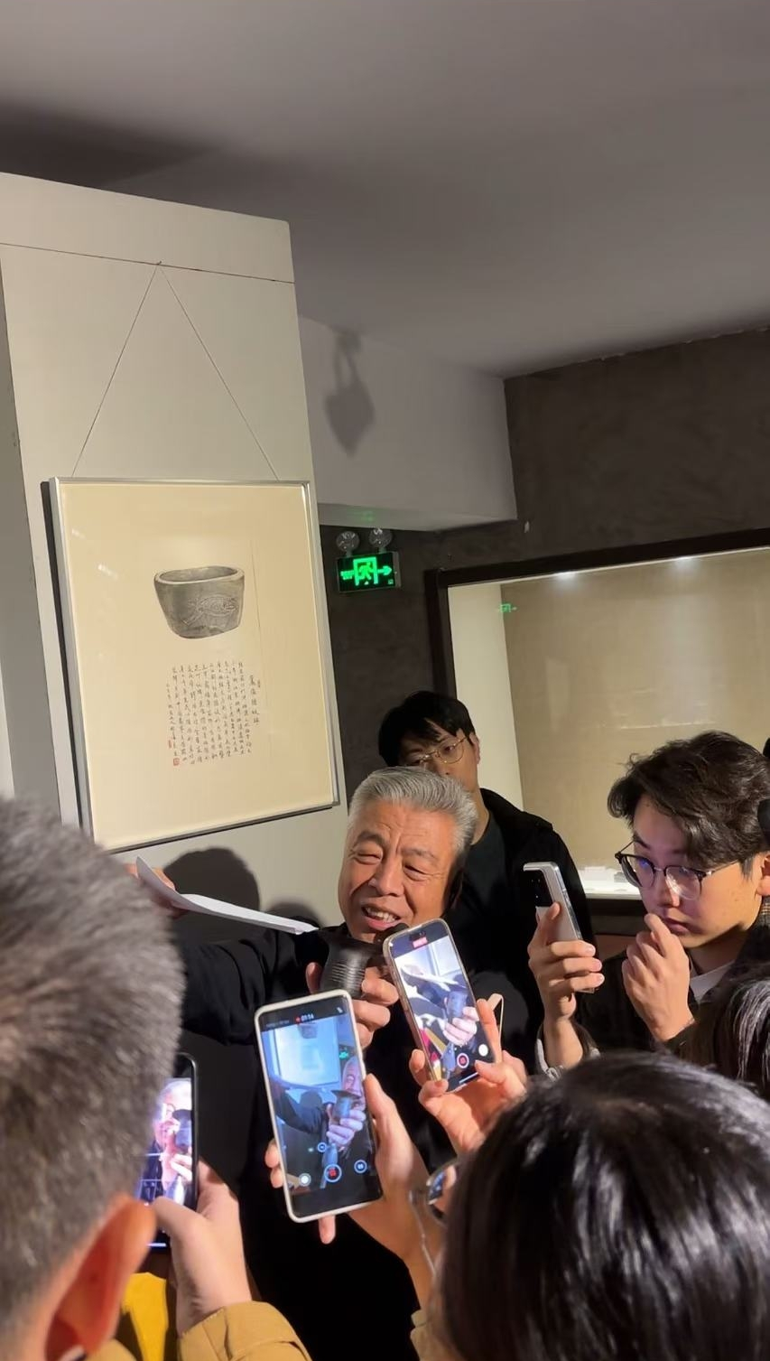 黑陶邢文化博物館館長邢葆東展示兩張相疊的A4紙，向記者解釋此為杯口的厚度。