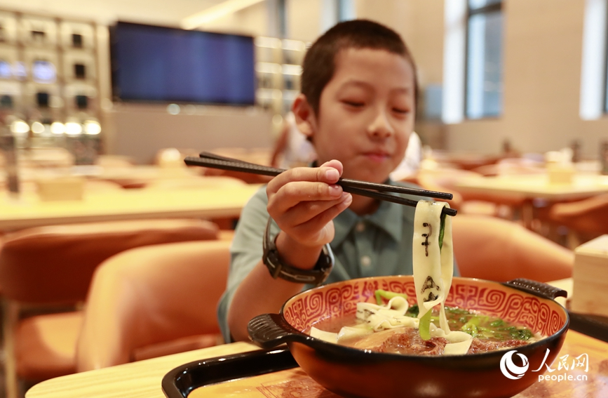 殷墟博物館推出的甲骨文面深受游客喜愛。人民網(wǎng)記者 慎志遠(yuǎn) 攝