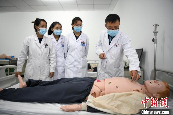 湖南中醫(yī)藥大學第一附屬醫(yī)院腦病科援藏醫(yī)生高曉峰(右一)為學生們進行體格檢查教學?！钊A峰 攝